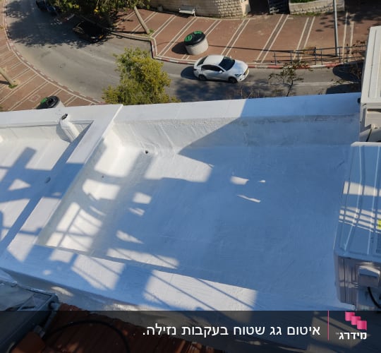 גג אטום בצבע לבן עם צללים של מבנה